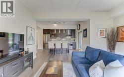 Open concept living space with wood-finish flooring extending into the kitchen -