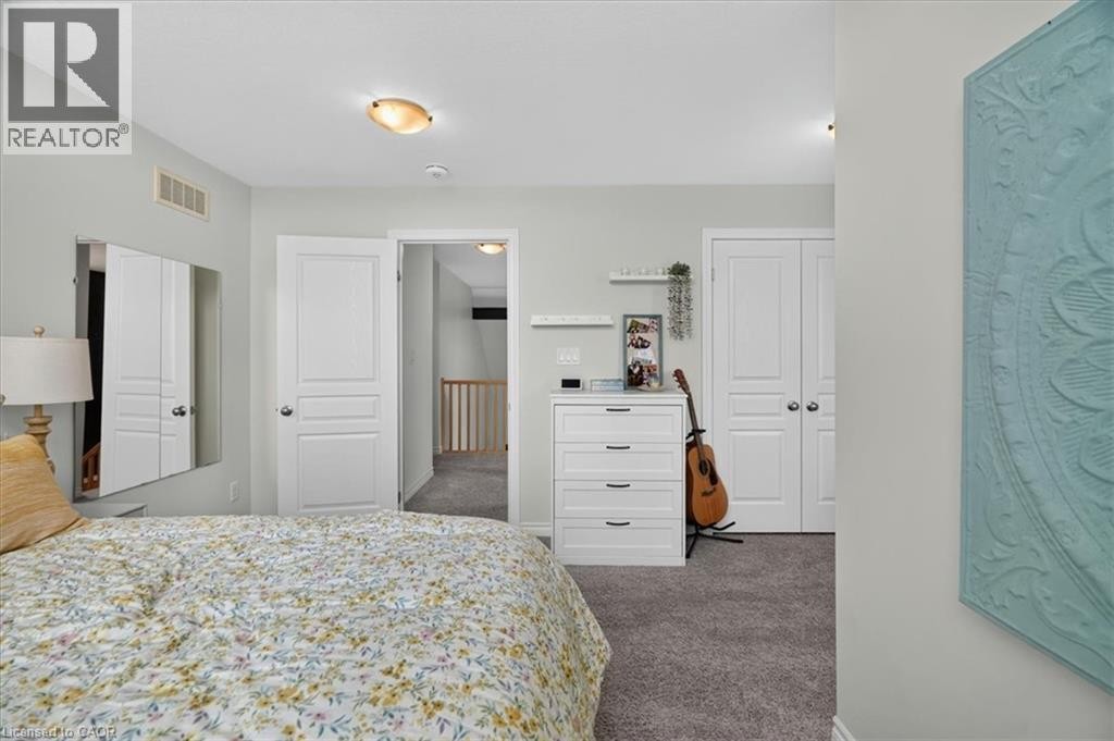 Carpeted room with light gray walls, featuring white paneled doors and a semi-flush mount ceiling light - 87 Boyd Boulevard, Thamesford, ON - Indoor Photo Showing Bedroom
