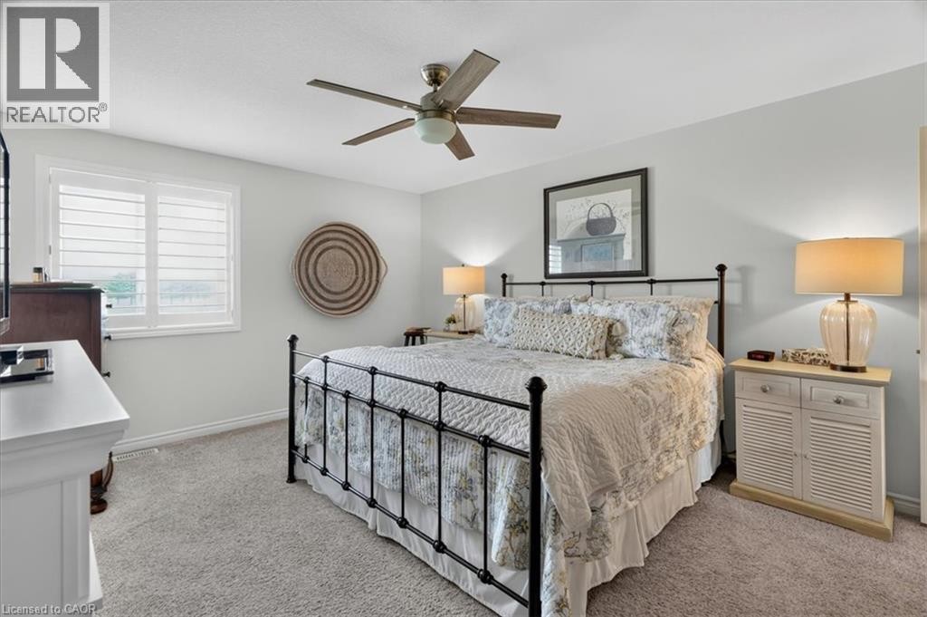 Plush carpeting throughout, paired with a ceiling fan featuring a central light fixture - 87 Boyd Boulevard, Thamesford, ON - Indoor Photo Showing Bedroom