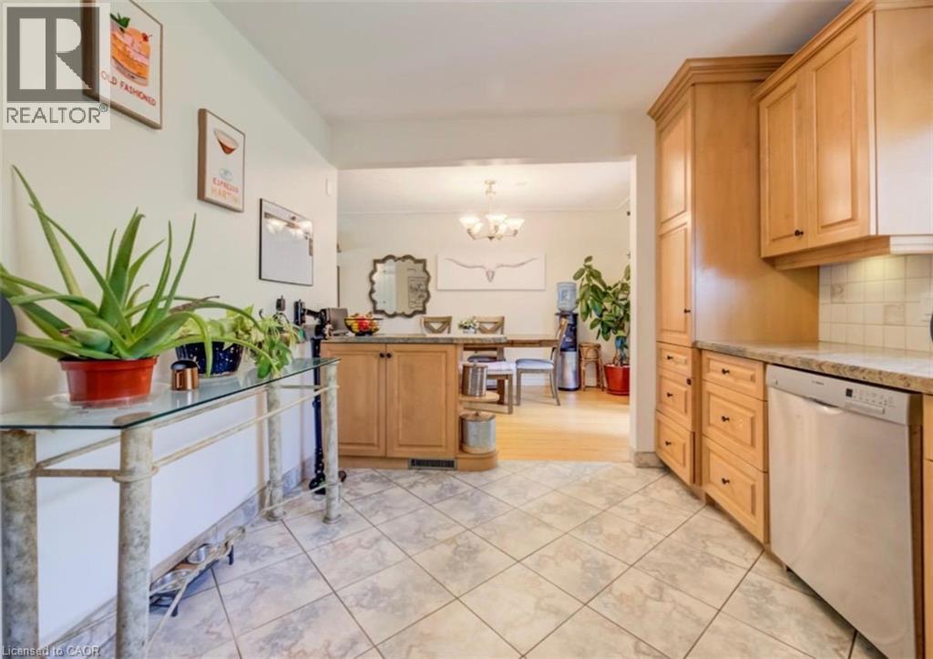 Kitchen featuring tile flooring, light wood cabinetry, stone countertops, and a stainless steel dishwasher - 209 Willowdale Avenue Unit# Upper, Waterloo, ON - Indoor Photo Showing Kitchen
