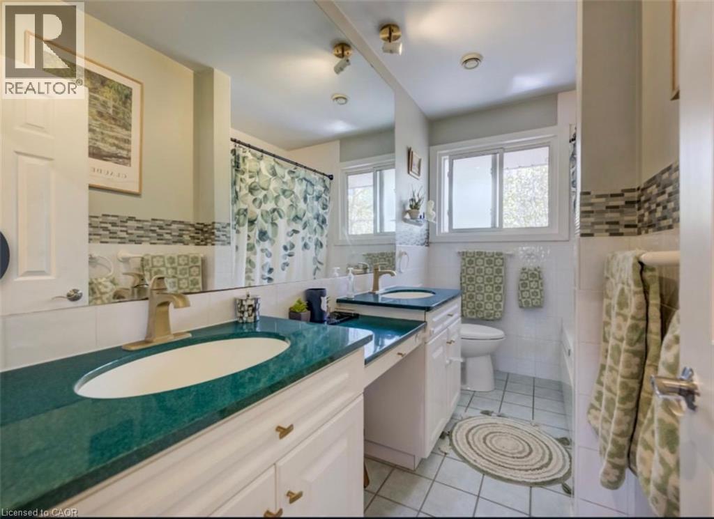Bathroom featuring a dual vanity with green countertops, white cabinetry, and brushed gold fixtures - 209 Willowdale Avenue Unit# Upper, Waterloo, ON - Indoor Photo Showing Bathroom