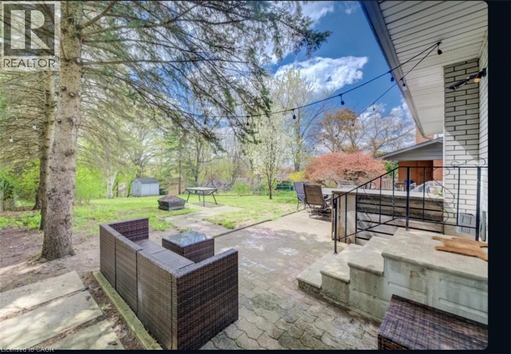 Spacious backyard featuring a paver patio, mature trees, and a storage shed - 209 Willowdale Avenue Unit# Upper, Waterloo, ON - Outdoor