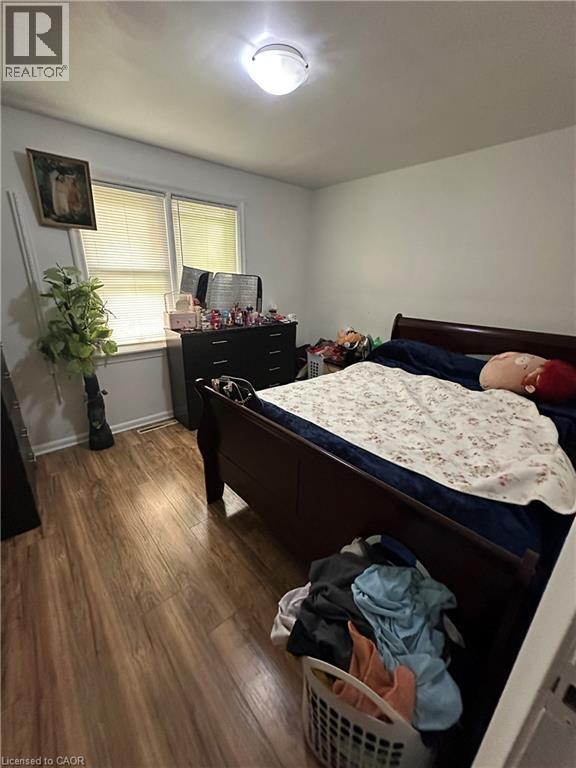 Bedroom featuring wood-finish flooring, white walls, and a ceiling-mounted light fixture - 240 West 2Nd Street, Hamilton, ON - Indoor Photo Showing Bedroom