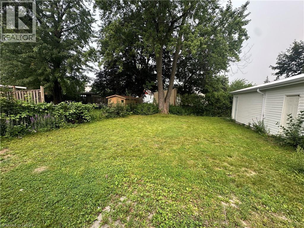 Expansive green space featuring established trees, perimeter fencing, and a storage shed - 240 West 2Nd Street, Hamilton, ON - Outdoor