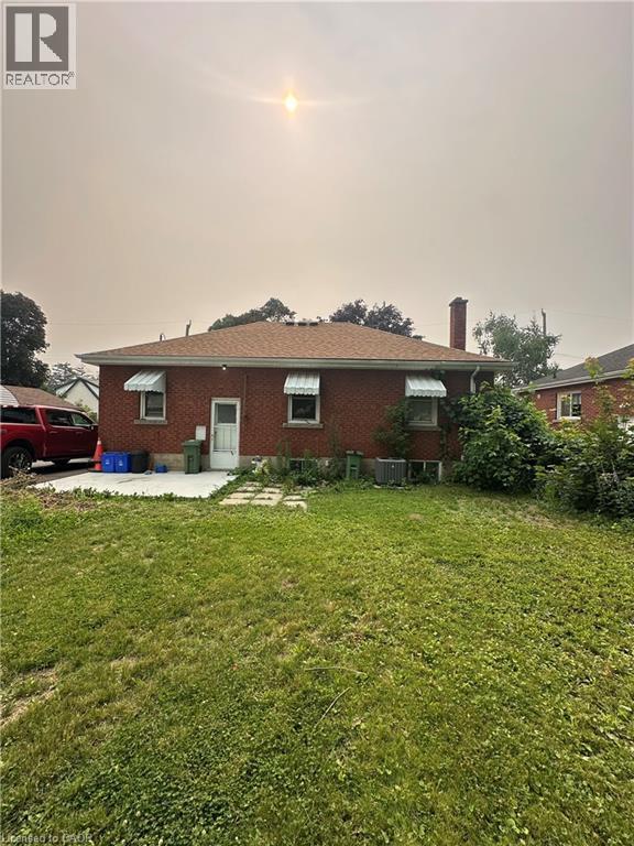Rear exterior featuring red brick construction and a brown shingle roof - 240 West 2Nd Street, Hamilton, ON - Outdoor