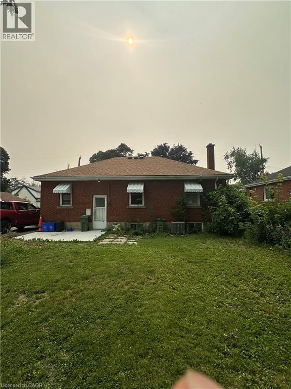Brick exterior featuring a gabled roof and four window awnings - 240 West 2Nd Street, Hamilton, ON - Outdoor