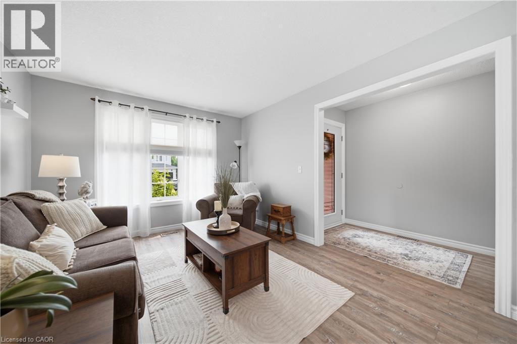 Living area featuring light wood-finish flooring, neutral wall tones, and a large window with white trim - 79 Beaverbrook Crescent, Cambridge, ON - Indoor Photo Showing Living Room