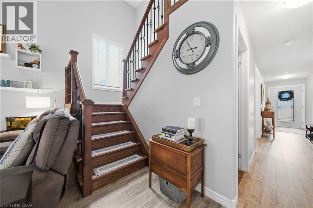 Hardwood staircase with wrought iron spindles and a window at the landing - 79 Beaverbrook Crescent, Cambridge, ON - Indoor Photo Showing Other Room
