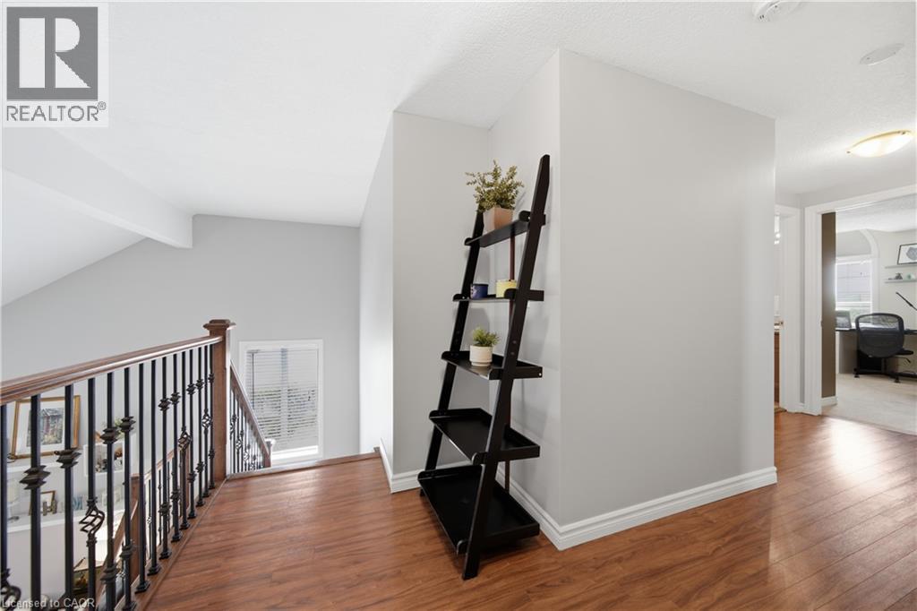 Upper landing featuring wood-finish flooring, a wrought iron and wood balustrade, and a recessed ceiling light - 79 Beaverbrook Crescent, Cambridge, ON - Indoor Photo Showing Other Room