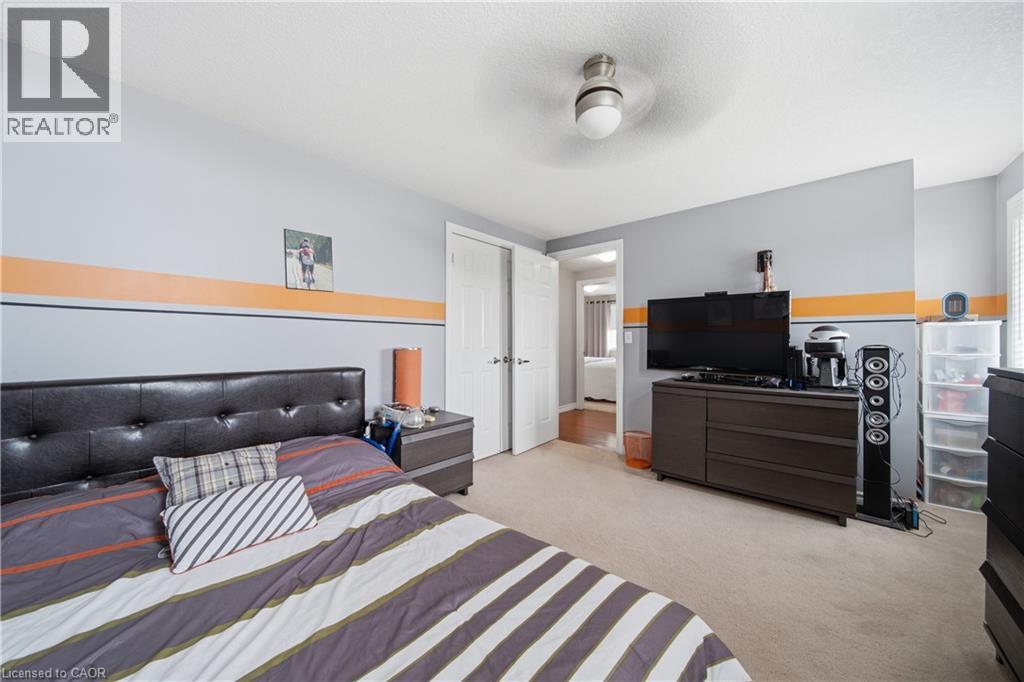 Carpeted room featuring a ceiling fan with light, white trim, and a white interior door - 79 Beaverbrook Crescent, Cambridge, ON - Indoor Photo Showing Bedroom