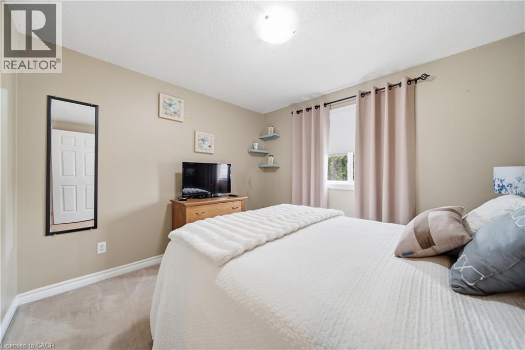 Carpeted room with neutral-toned walls, a window with light-blocking drapes, a flush-mount ceiling light, and white baseboards - 79 Beaverbrook Crescent, Cambridge, ON - Indoor Photo Showing Bedroom