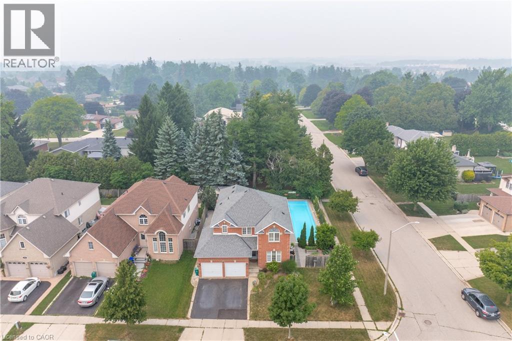 Brick exterior residence featuring an in-ground swimming pool, an attached two-car garage, and a paved driveway - 79 Beaverbrook Crescent, Cambridge, ON - Outdoor With View