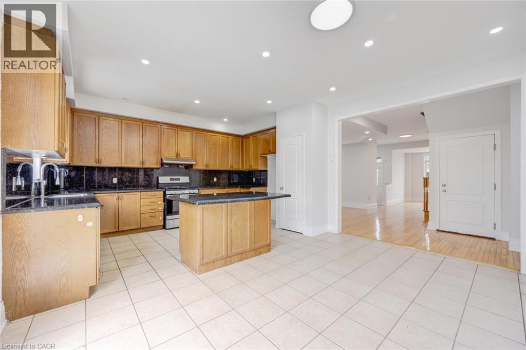 Kitchen featuring wood-finish cabinetry, dark countertops, and a tile floor - 5 Freshspring Drive, Brampton, ON - Indoor Photo Showing Kitchen