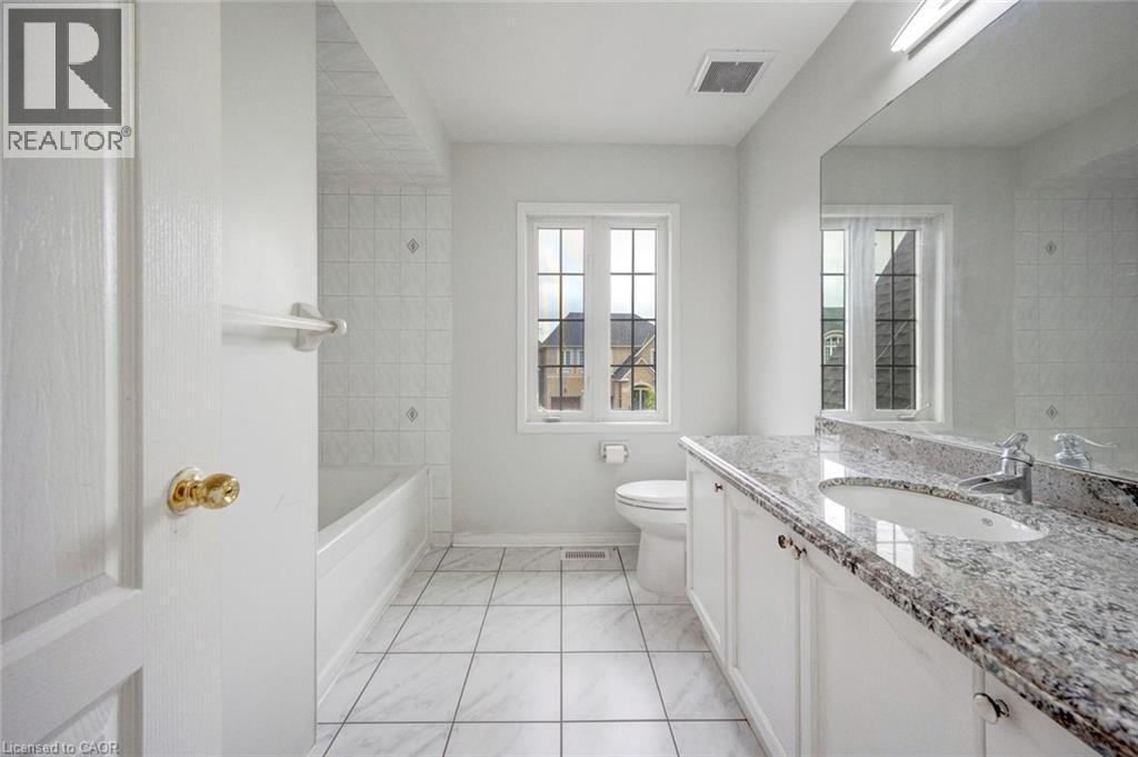 Bathroom featuring a white vanity with a light-toned patterned countertop, an undermount sink, and chrome fixtures - 5 Freshspring Drive, Brampton, ON - Indoor Photo Showing Bathroom