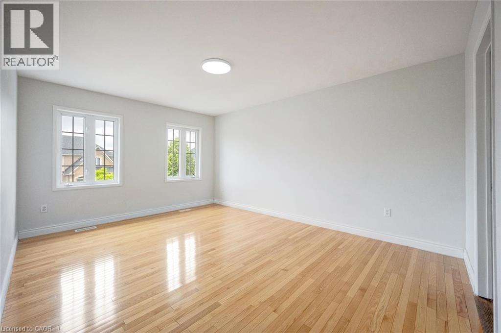 Spacious room featuring wood-finish flooring and two multi-pane windows - 5 Freshspring Drive, Brampton, ON - Indoor Photo Showing Other Room