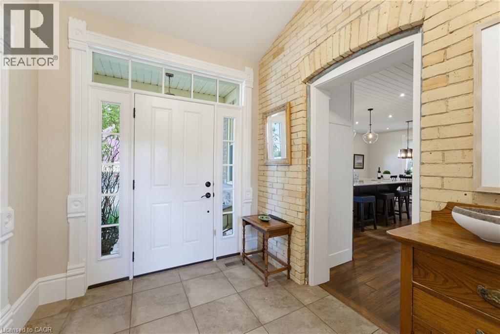 Entry foyer featuring a white paneled door with sidelights, a transom window, and intricate trim work - 8430 Road 146, Listowel, ON - Indoor Photo Showing Other Room