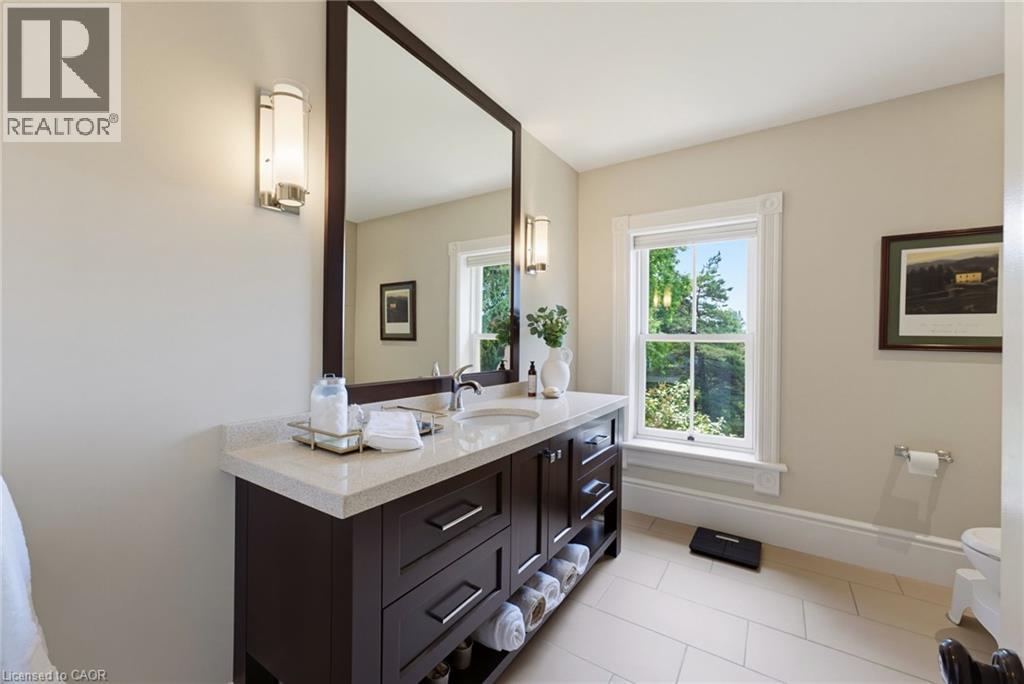 Vanity featuring a light-colored countertop, undermount sink, and dark wood-finish cabinetry - 8430 Road 146, Listowel, ON - Indoor Photo Showing Bathroom