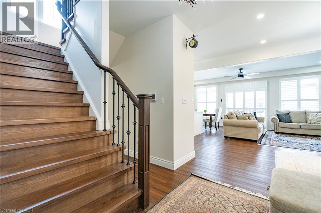 Hardwood staircase with wrought iron balusters and a dark wood handrail - 122 Iron Gate Street, Kitchener, ON - Indoor Photo Showing Other Room