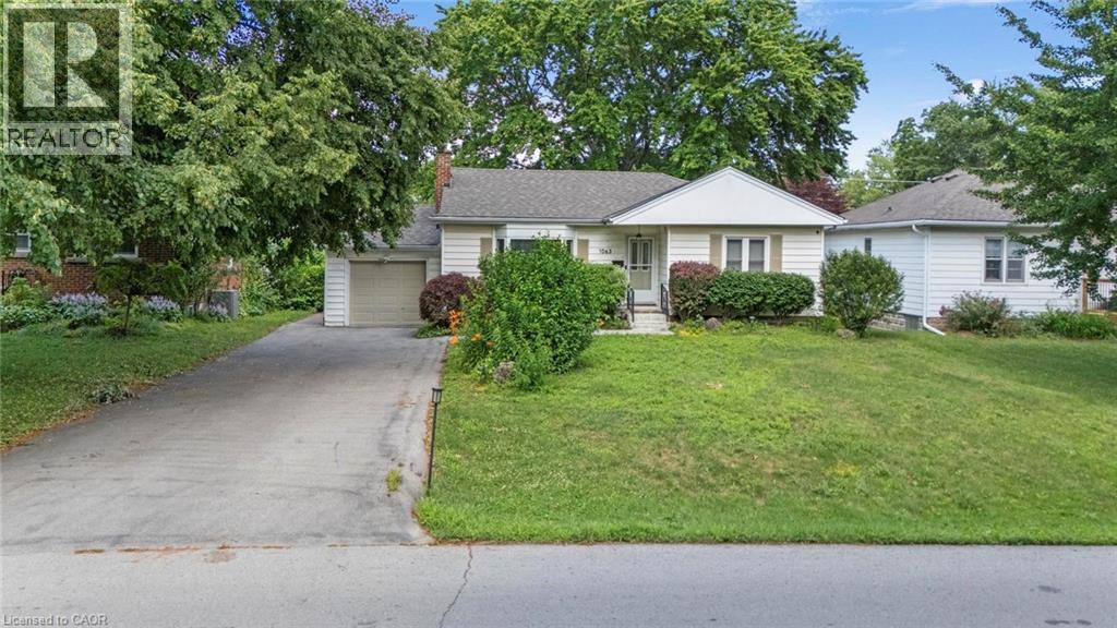 Single-story residence featuring light-colored siding, an attached garage, and a concrete driveway - 1063 Joan Drive, Burlington, ON - Outdoor