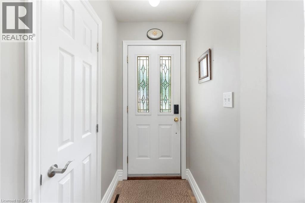 Entryway featuring a white door with decorative glass inserts, a smart lock, and light gray wall paint - 1063 Joan Drive, Burlington, ON - Indoor Photo Showing Other Room