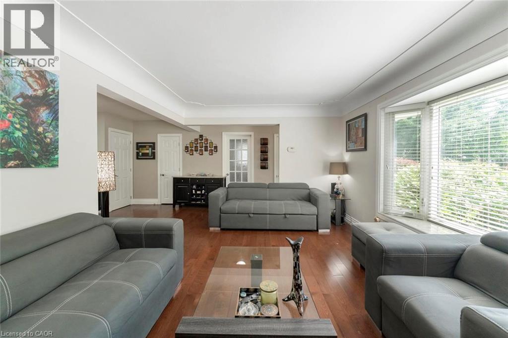 Living area featuring wood-finish flooring, a bay window with blinds, and white crown molding - 1063 Joan Drive, Burlington, ON - Indoor Photo Showing Living Room