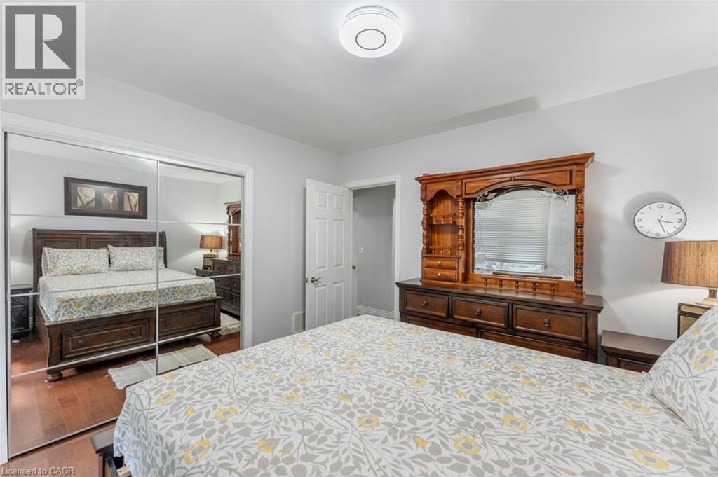 Room featuring mirrored sliding closet doors, light gray wall paint, and a ceiling-mounted light fixture - 1063 Joan Drive, Burlington, ON - Indoor Photo Showing Bedroom
