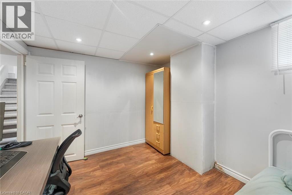 Room with wood-finish flooring, light grey walls, and a white paneled door - 1063 Joan Drive, Burlington, ON - Indoor