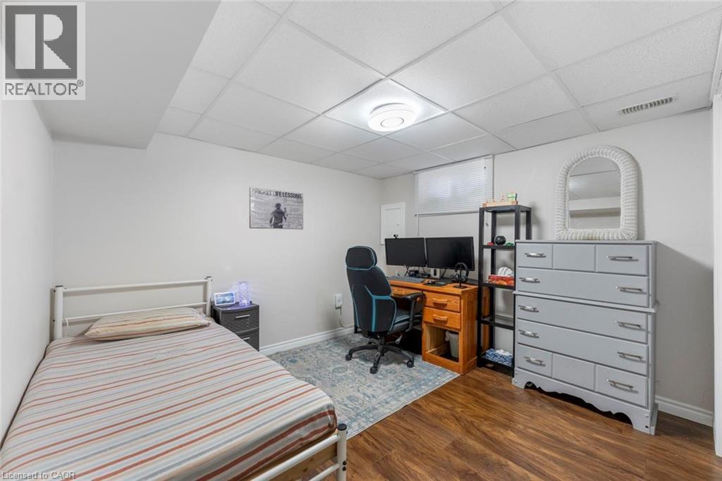 Finished room featuring wood-finish flooring, drop ceiling, and white painted walls - 1063 Joan Drive, Burlington, ON - Indoor