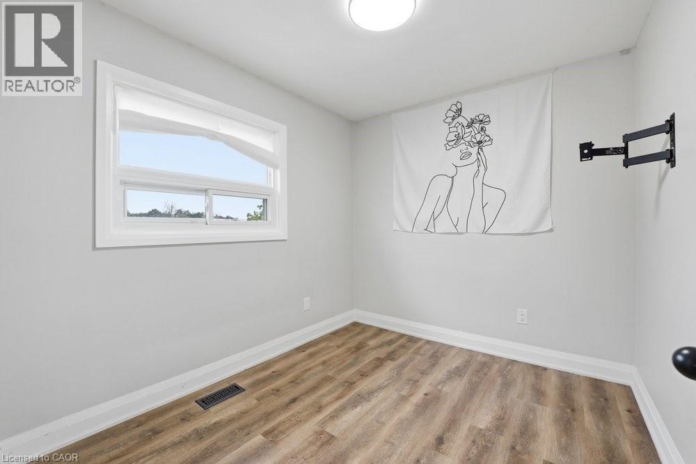 Room featuring light gray walls, wood-finish flooring, and white baseboards - 773 Lawrence Road, Hamilton, ON - Indoor Photo Showing Other Room