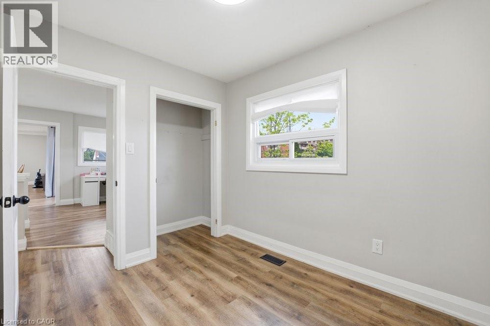 Bright room with wood-finish flooring, light grey walls, and a recessed ceiling light - 773 Lawrence Road, Hamilton, ON - Indoor Photo Showing Other Room