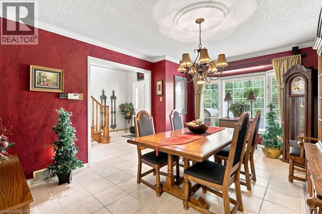 Dining area featuring tiled flooring, crown molding, and a bay window - 39 Everwood Run, Kitchener, ON - Indoor Photo Showing Dining Room