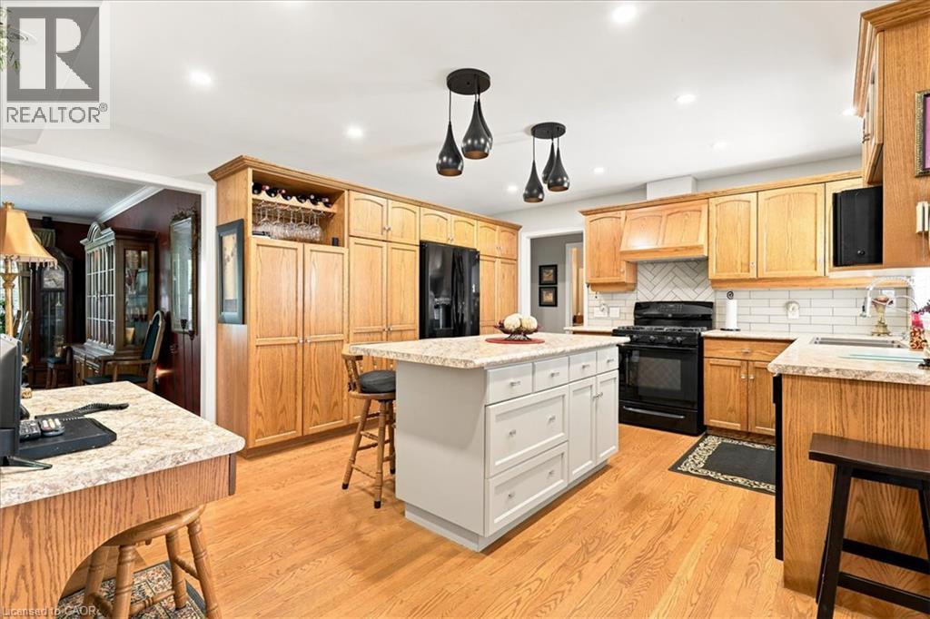 Kitchen featuring wood-finish flooring, recessed lighting, and a center island with pendant lights - 39 Everwood Run, Kitchener, ON - Indoor Photo Showing Kitchen