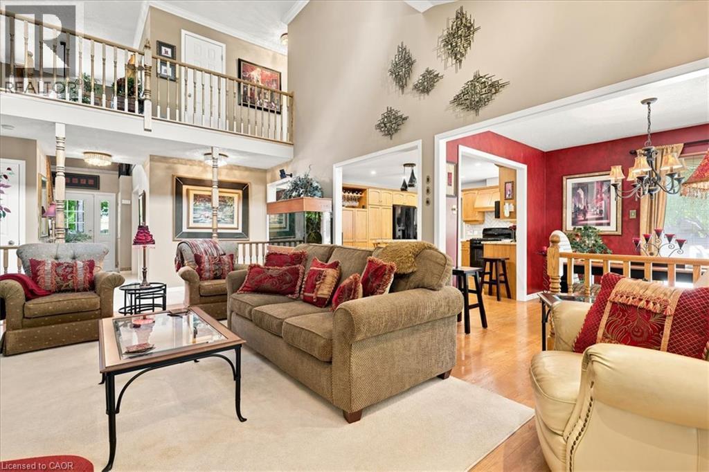 Two-story living area with an upper-level balcony featuring white spindle railings - 39 Everwood Run, Kitchener, ON - Indoor Photo Showing Living Room