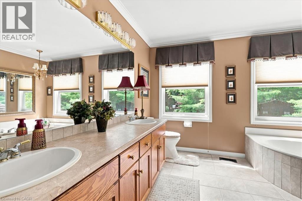 Bathroom featuring a dual vanity with integrated sinks, wood cabinetry, and a light-toned countertop - 39 Everwood Run, Kitchener, ON - Indoor Photo Showing Bathroom
