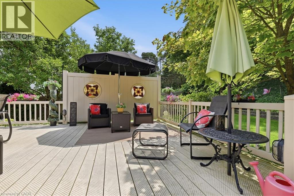 Spacious outdoor deck featuring composite decking, white railing, and a privacy wall with decorative inserts - 39 Everwood Run, Kitchener, ON - Outdoor With Deck Patio Veranda With Exterior