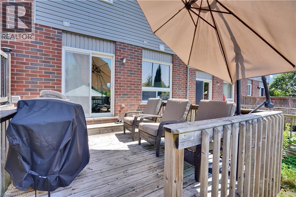 Wood-finish deck with a built-in privacy wall, red brick exterior, and vinyl siding - 60 Featherstone Street, Kitchener, ON - Outdoor With Deck Patio Veranda With Exterior