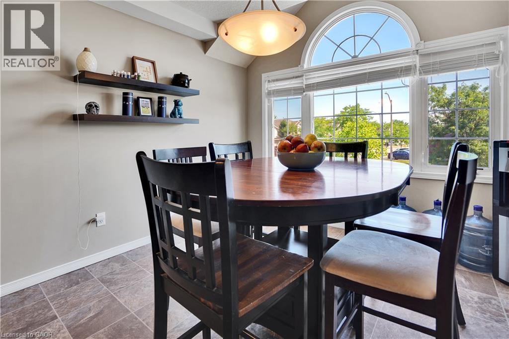 Dining area featuring a large arched transom window, wood-finish flooring, and built-in floating wall shelves - 60 Featherstone Street, Kitchener, ON - Indoor Photo Showing Dining Room