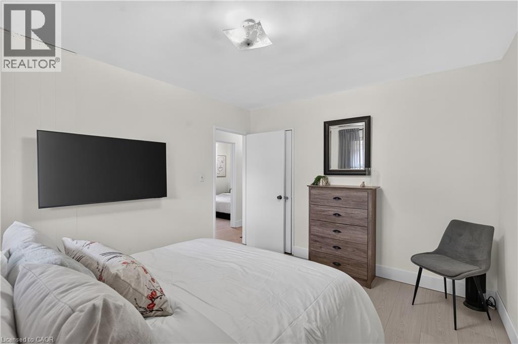 Interior room featuring light-toned walls, wood-finish flooring, and a flush-mount ceiling light fixture - 236 Hammersmith Court, Burlington, ON - Indoor Photo Showing Bedroom