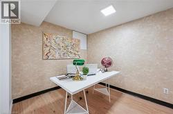 Interior room featuring wood-finish flooring, textured walls, and a rectangular ceiling light fixture - 