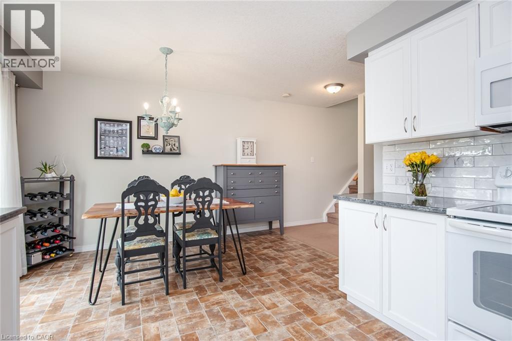 Open-concept living space featuring wood-finish flooring, a contemporary chandelier, and a neutral color palette - 38 David Bergey Drive, Kitchener, ON - Indoor Photo Showing Kitchen