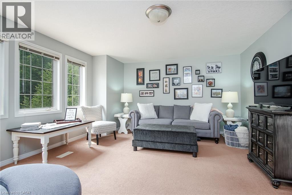 Spacious room featuring multiple windows with grid patterns, light-colored walls, and a ceiling-mounted light fixture - 38 David Bergey Drive, Kitchener, ON - Indoor Photo Showing Living Room