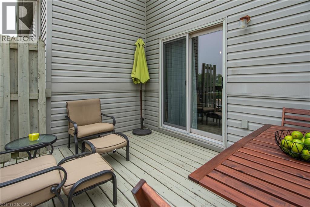 Private outdoor deck featuring horizontal siding, a sliding glass door, and exterior lighting - 38 David Bergey Drive, Kitchener, ON - Outdoor With Deck Patio Veranda With Exterior
