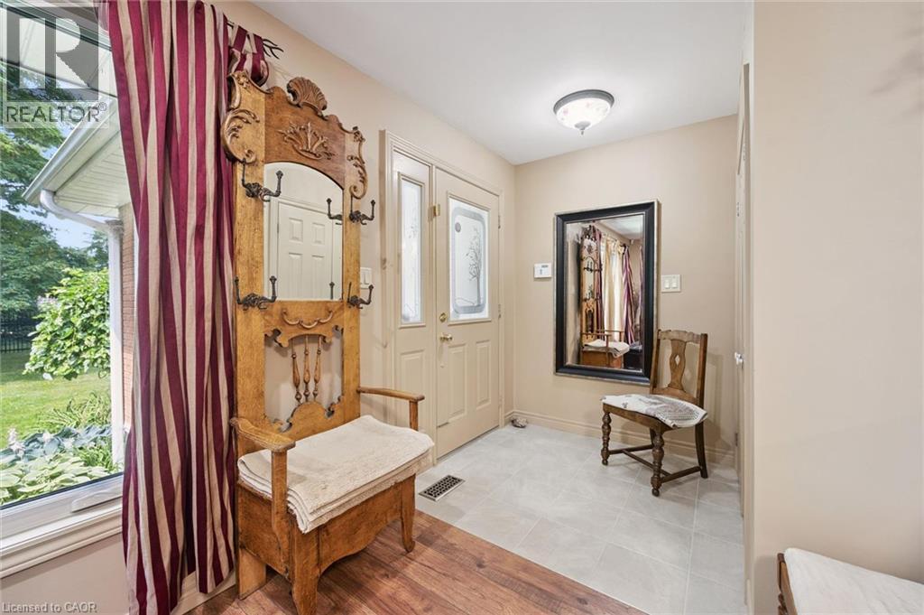 Entryway featuring a door with decorative glass inserts, light grey floor tiling, and neutral wall tones, glass inserts, light grey ceramic floor tiling and neutral wall tones - 410 Avenue Road, Cambridge, ON - Indoor Photo Showing Other Room