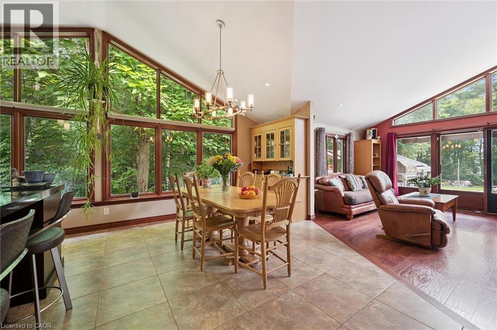 Dining area featuring a vaulted ceiling with Stainless Steel chandelier and an expansive wall of windows - 410 Avenue Road, Cambridge, ON - Indoor