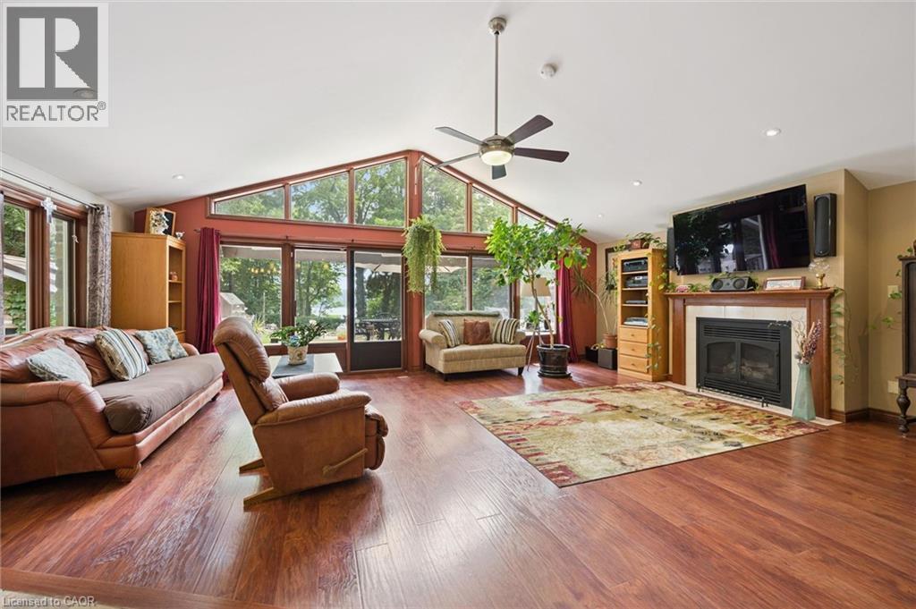 Spacious living area featuring wood-finish flooring, a vaulted ceiling with a ceiling fan, and recessed lighting - 410 Avenue Road, Cambridge, ON - Indoor Photo Showing Living Room With Fireplace