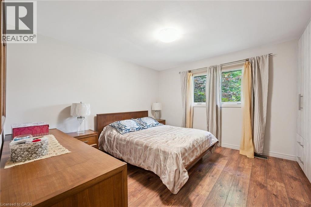Bedroom featuring country style laminate flooring, off white painted walls, with large integrated closet space and new crank style windows - 410 Avenue Road, Cambridge, ON - Indoor Photo Showing Bedroom