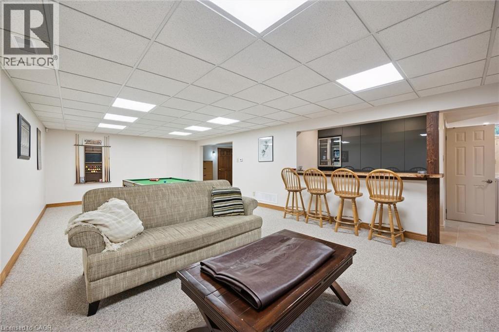Finished lower level featuring built in bar with high polished grey mirrored cabinetry, a stainless-steel dual zone French door beverage refrigerator and a pool table area - 410 Avenue Road, Cambridge, ON - Indoor Photo Showing Basement