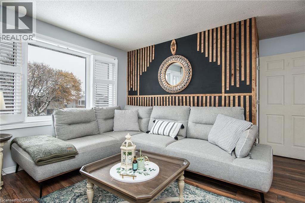 Living area featuring a prominent accent wall with vertical wood paneling and a dark painted background - 67 Pinemeadow Crescent, Waterloo, ON - Indoor Photo Showing Living Room