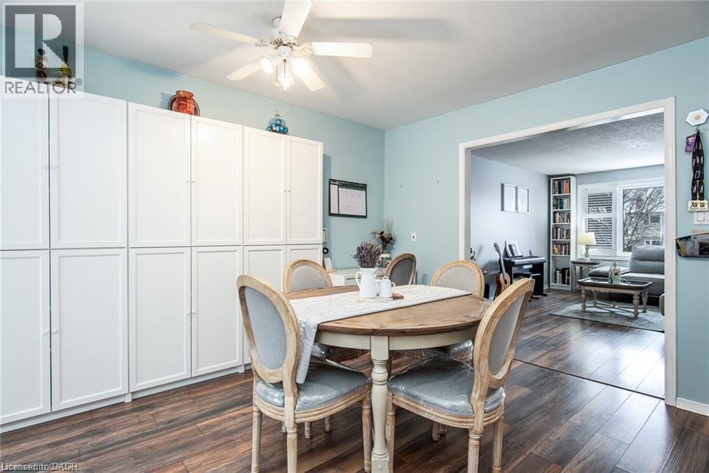 Dining area featuring extensive built-in white cabinetry, wood-finish flooring, and a ceiling fan - 67 Pinemeadow Crescent, Waterloo, ON - Indoor Photo Showing Dining Room