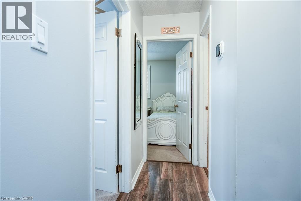 Hallway with wood-finish flooring, light grey painted walls, and white trim - 67 Pinemeadow Crescent, Waterloo, ON - Indoor Photo Showing Other Room